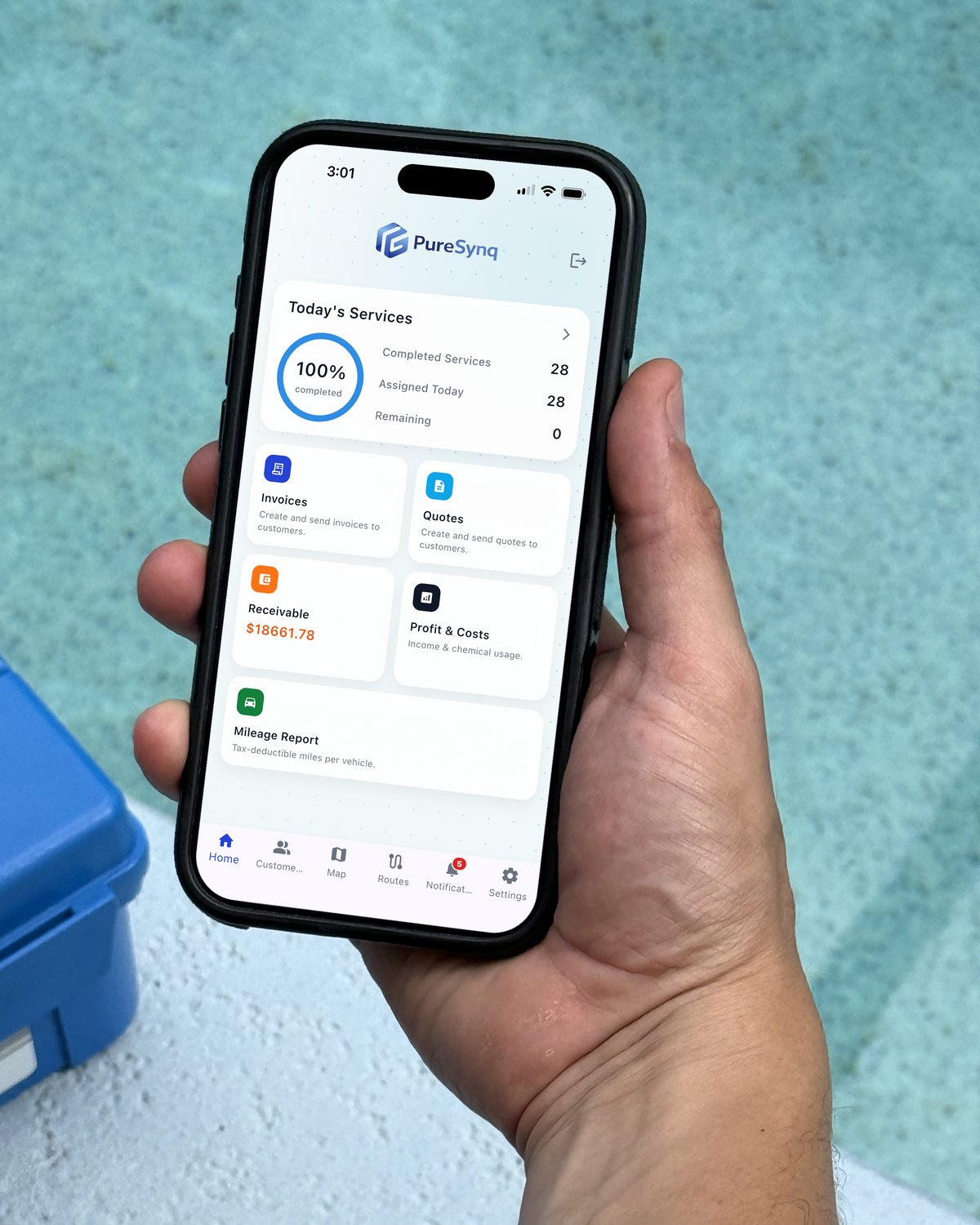 A technician holding a phone with the PureSynq home screen, at a pool